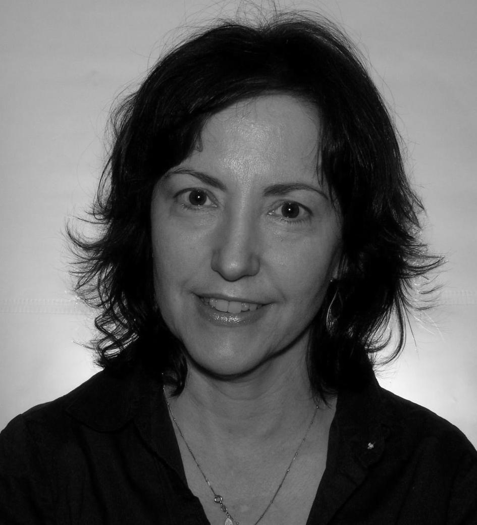 A black and white photo of a woman smiling and looking into the camera.