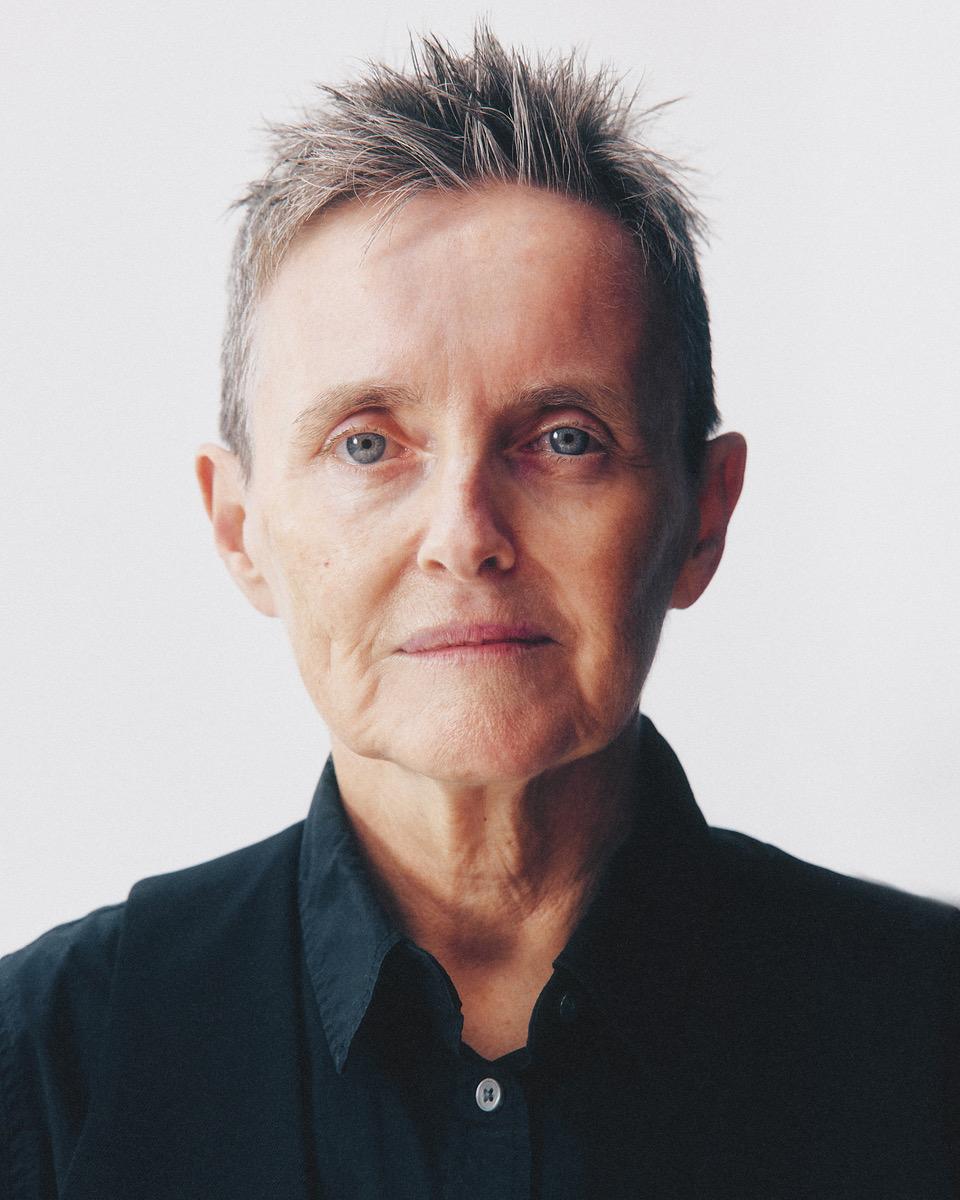 Headshot of a 60-year-old white woman with short hair in a black shirt and vest.