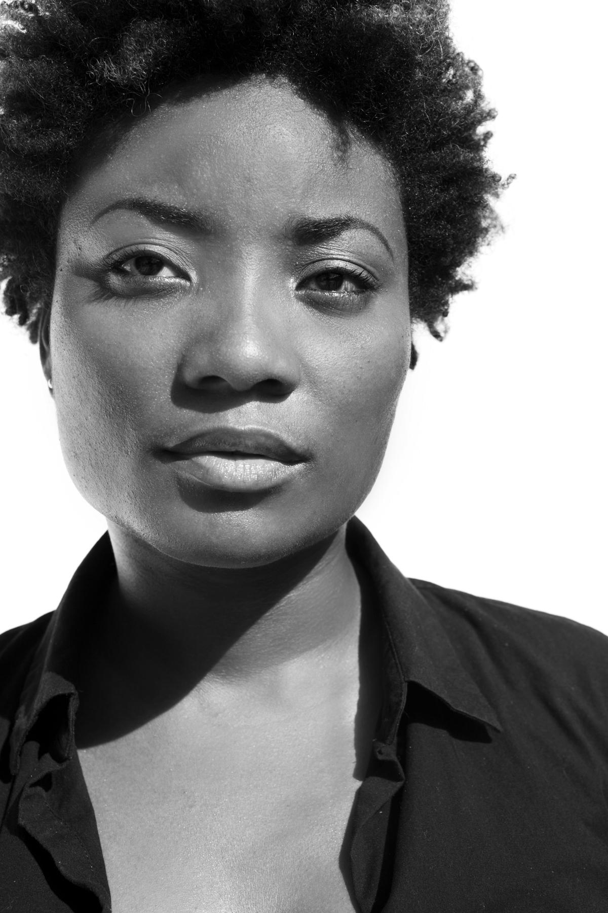 A black and white portrait of a woman with a serious expression looking off camera.