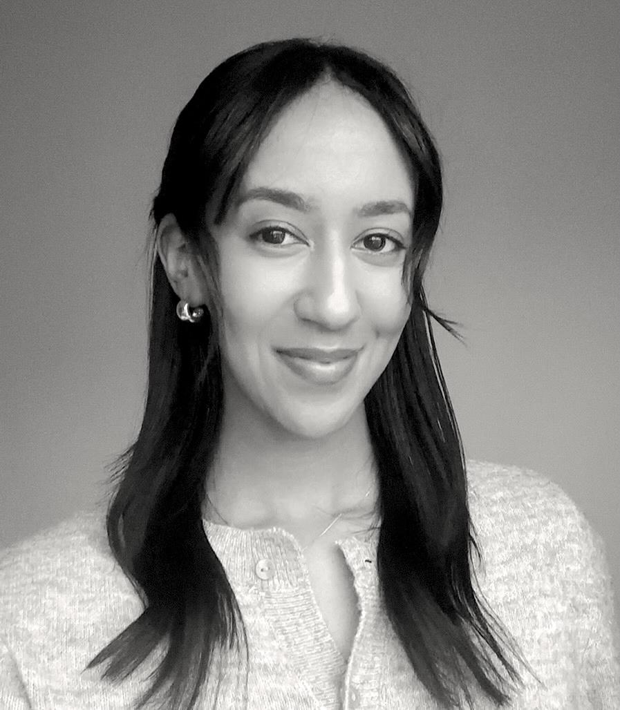 A black and white portrait of a woman with long, dark hair smiling at the camera.