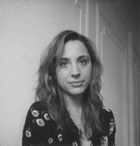 A black and white photo of a woman making a serious expression and looking into the camera.