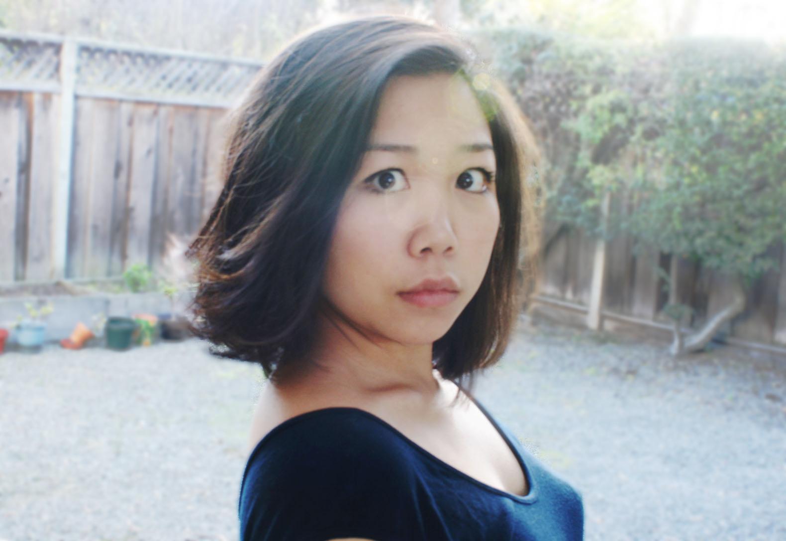 A photo of a woman with short hair looking into the camera with a serious expression.