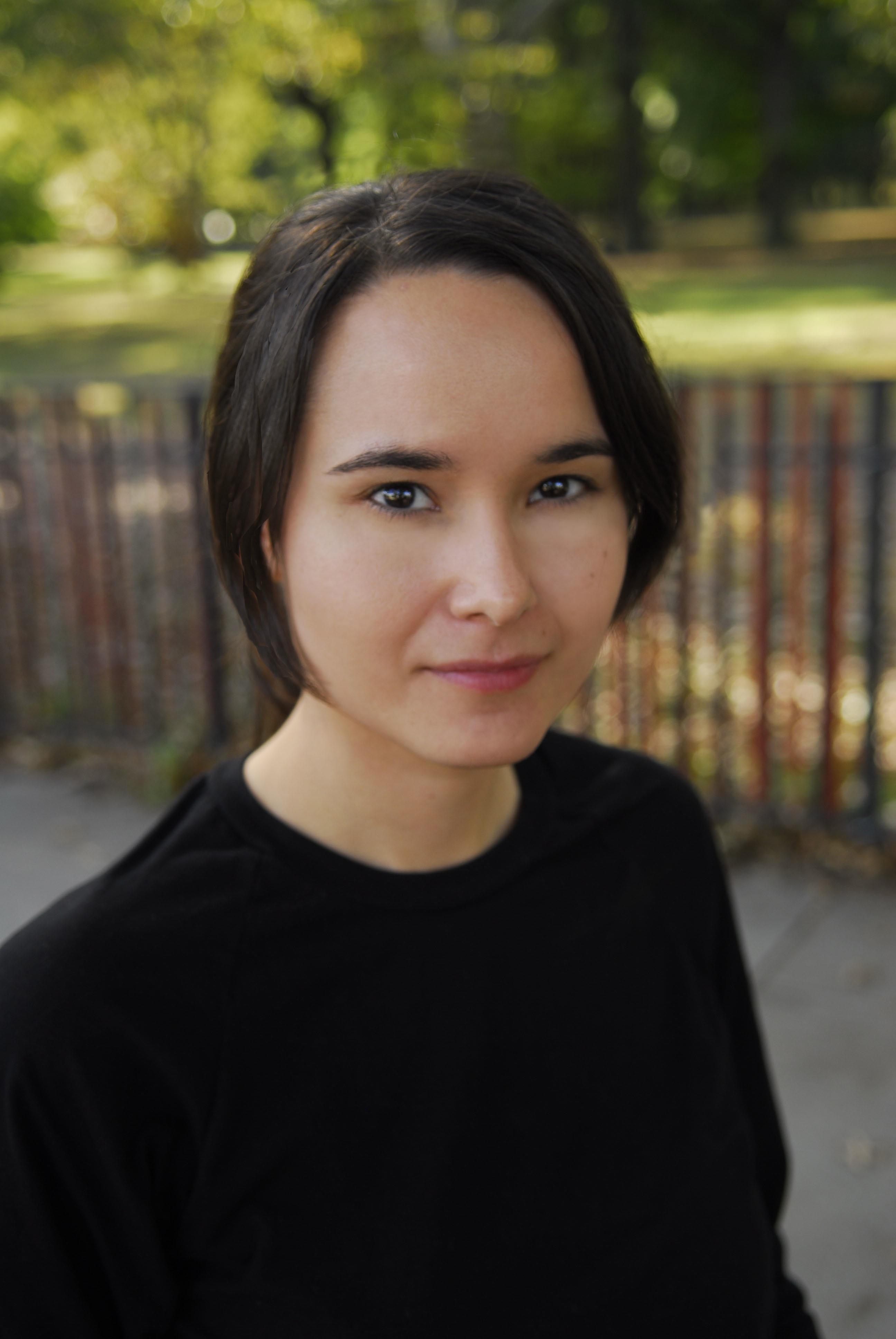 A portrait of a woman with a bob looking into the camera and smiling.