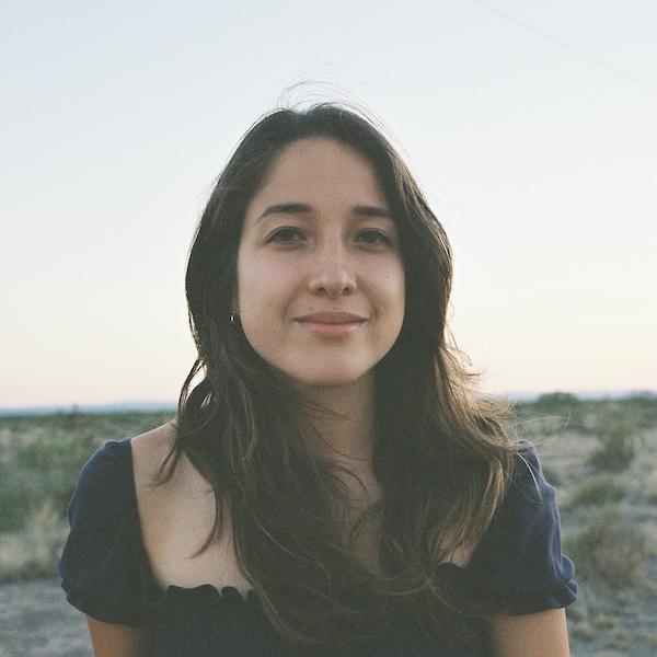 A portrait of a woman in a desert in Texas smiling at the camera.