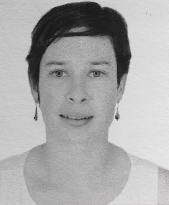 A black and white portrait of a woman smiling and looking into the camera.