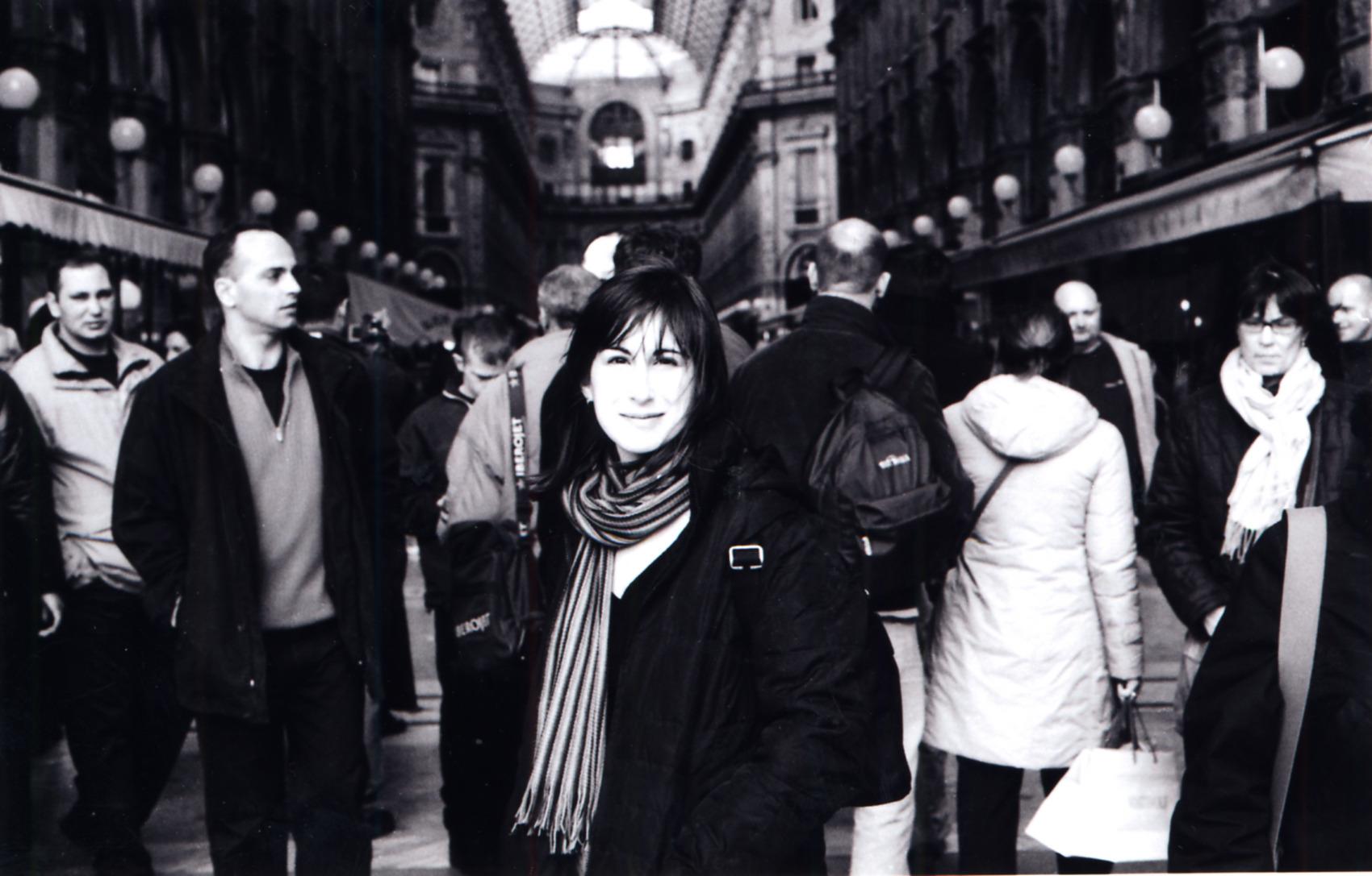 Robin Hessman stands in a crowd of people looking directly at the camera. The photo is in Black and white.