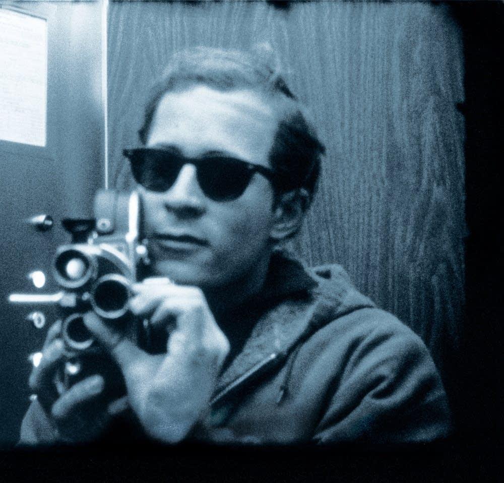 An archival image of a man with a bolex 16mm camera.